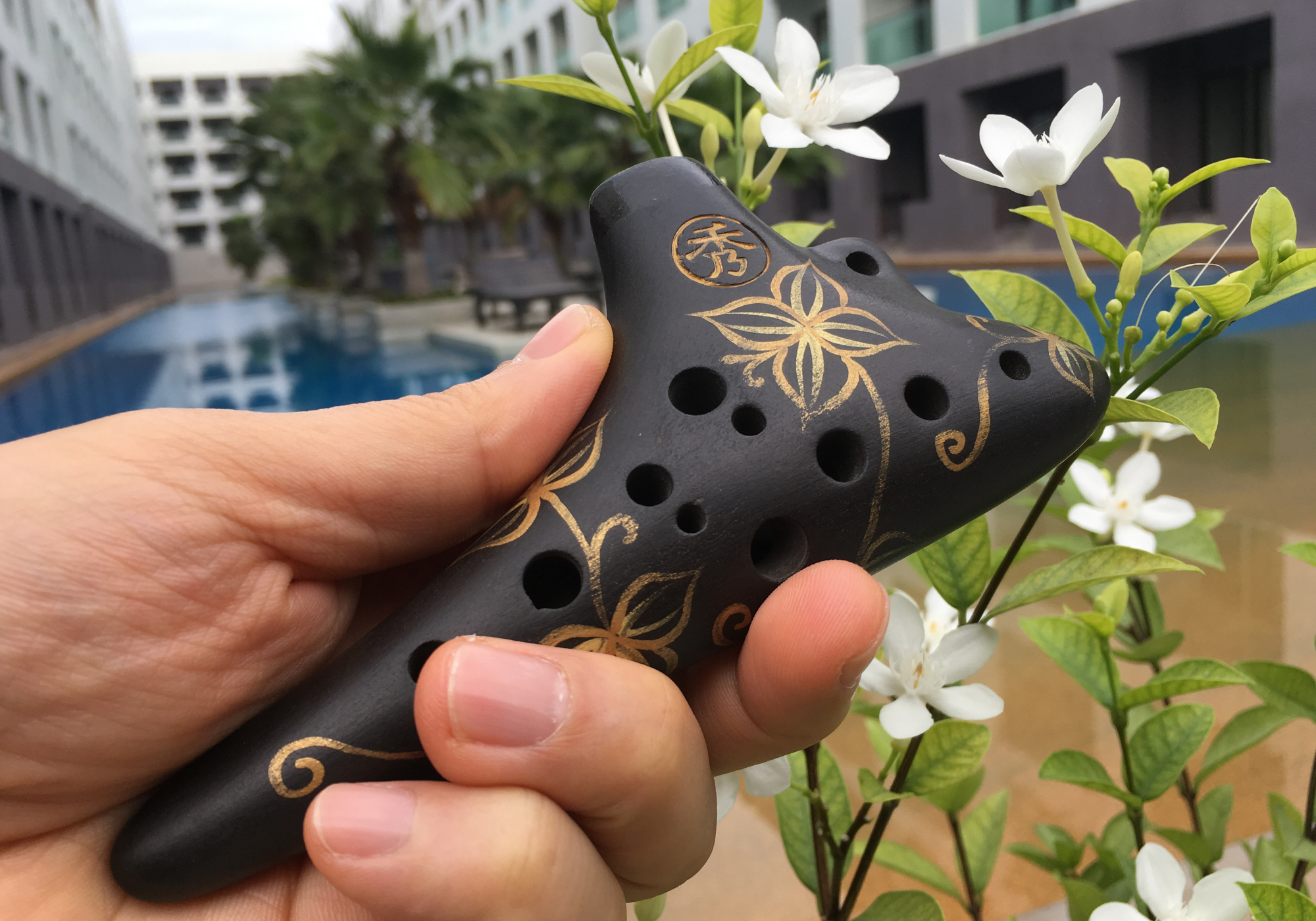 Uma Ocarina de 12 furos sendo segurada